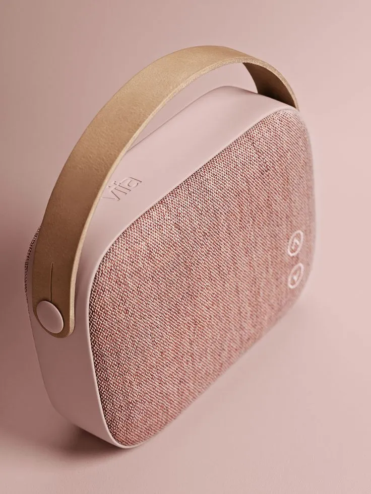 a pink and gold colored speaker on a pink background