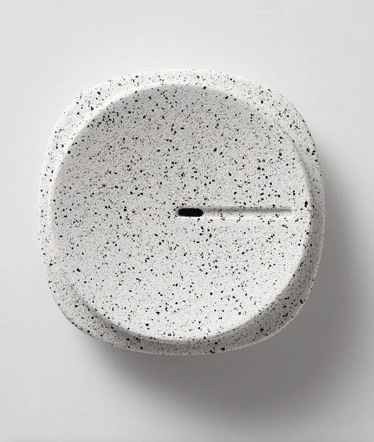 a white clock with black speckles on it