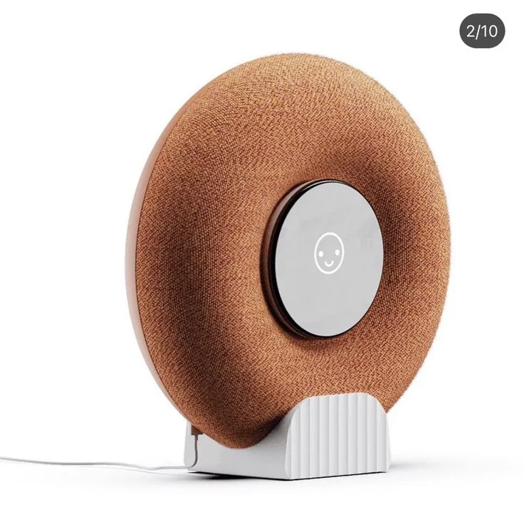 an orange and white speaker with a cord attached to the back