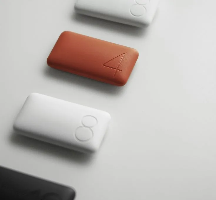 four electronic devices sitting on top of a white table next